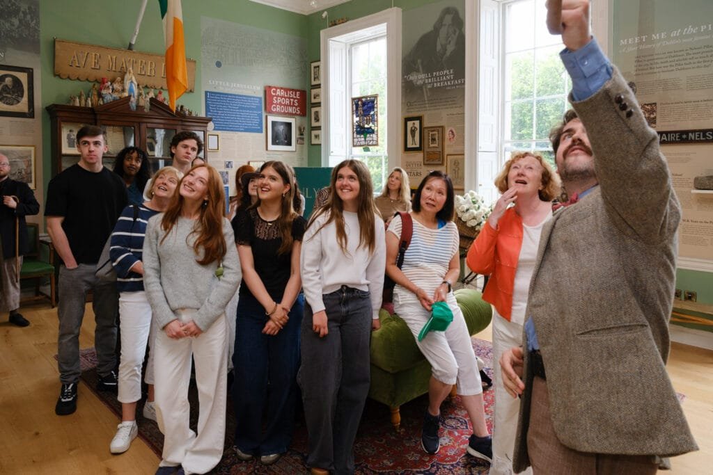 A tour guide points out some interesting artefacts on the wall of the 1916 Room in the Little Museum