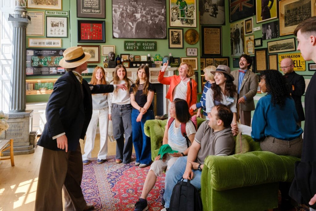 A tour guide interacting with some guests in the 1916 Room of the Little Museum