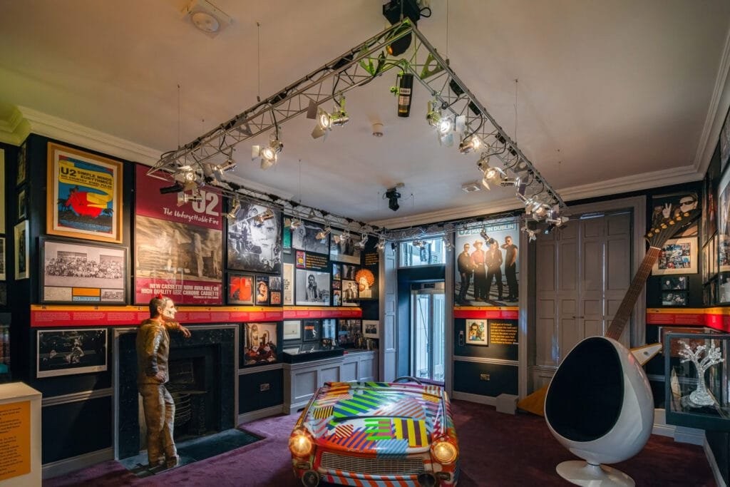 The U2: Made in Dublin exhibition in the Little Museum of Dublin, featuring some stage lighting, an oversized Gibson Explorer guitar and various artefacts telling the story of U2 along with some other iconic Dublin artists.