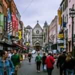 A bustling street scene in Dublin, showcasing diverse people and historic architecture.