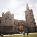 Stunning view of Saint Patrick's Cathedral with people enjoying a sunny day in Dublin, Ireland.