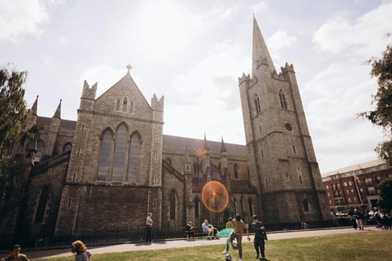Stunning view of Saint Patrick's Cathedral with people enjoying a sunny day in Dublin, Ireland.