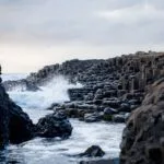 Dramatic basalt columns and crashing waves at Giant's Causeway, Northern Ireland.