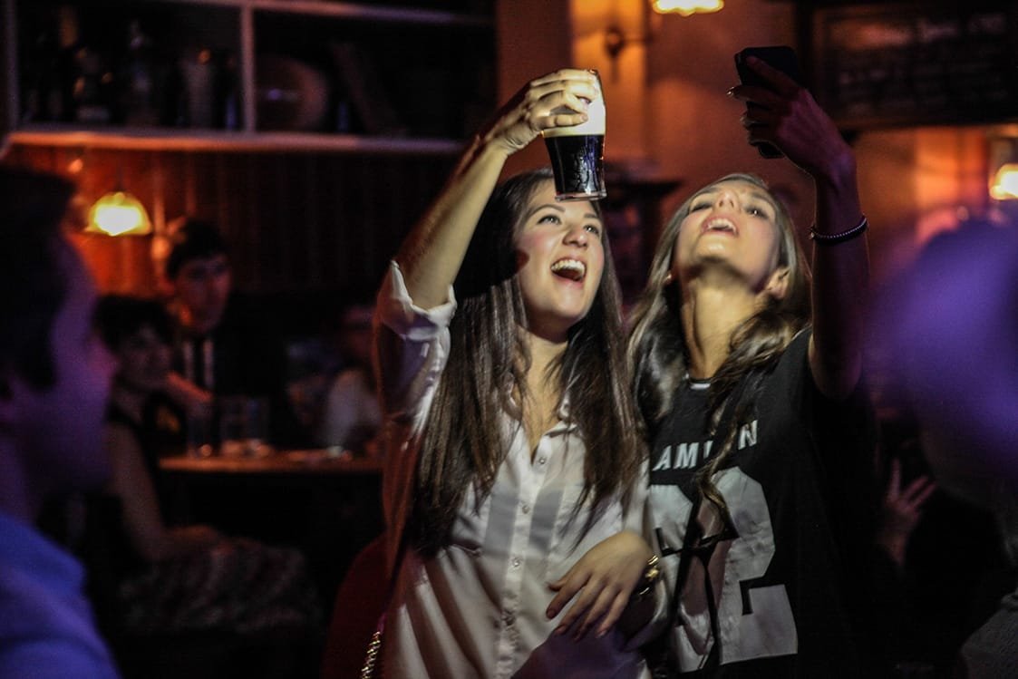 Friends raising a pint of Guinness on the Generation Pub Crawl in Dublin