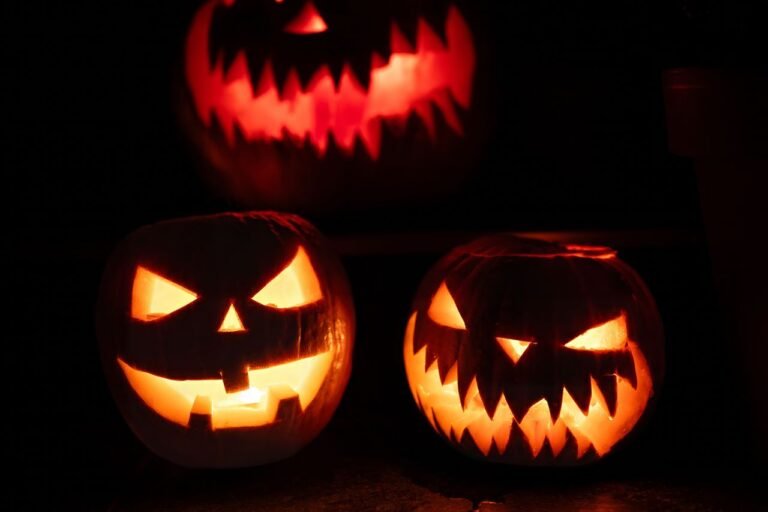 Three glowing jack-o'-lanterns at night, creating a spooky Halloween atmosphere.