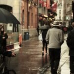 Rainy urban street scene in Dublin, Ireland with pedestrians and umbrellas.