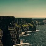 Breathtaking view of Ireland's Cliffs of Moher under a bright sky.