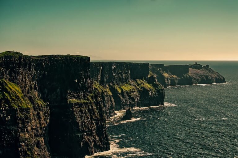 Breathtaking view of Ireland's Cliffs of Moher under a bright sky.