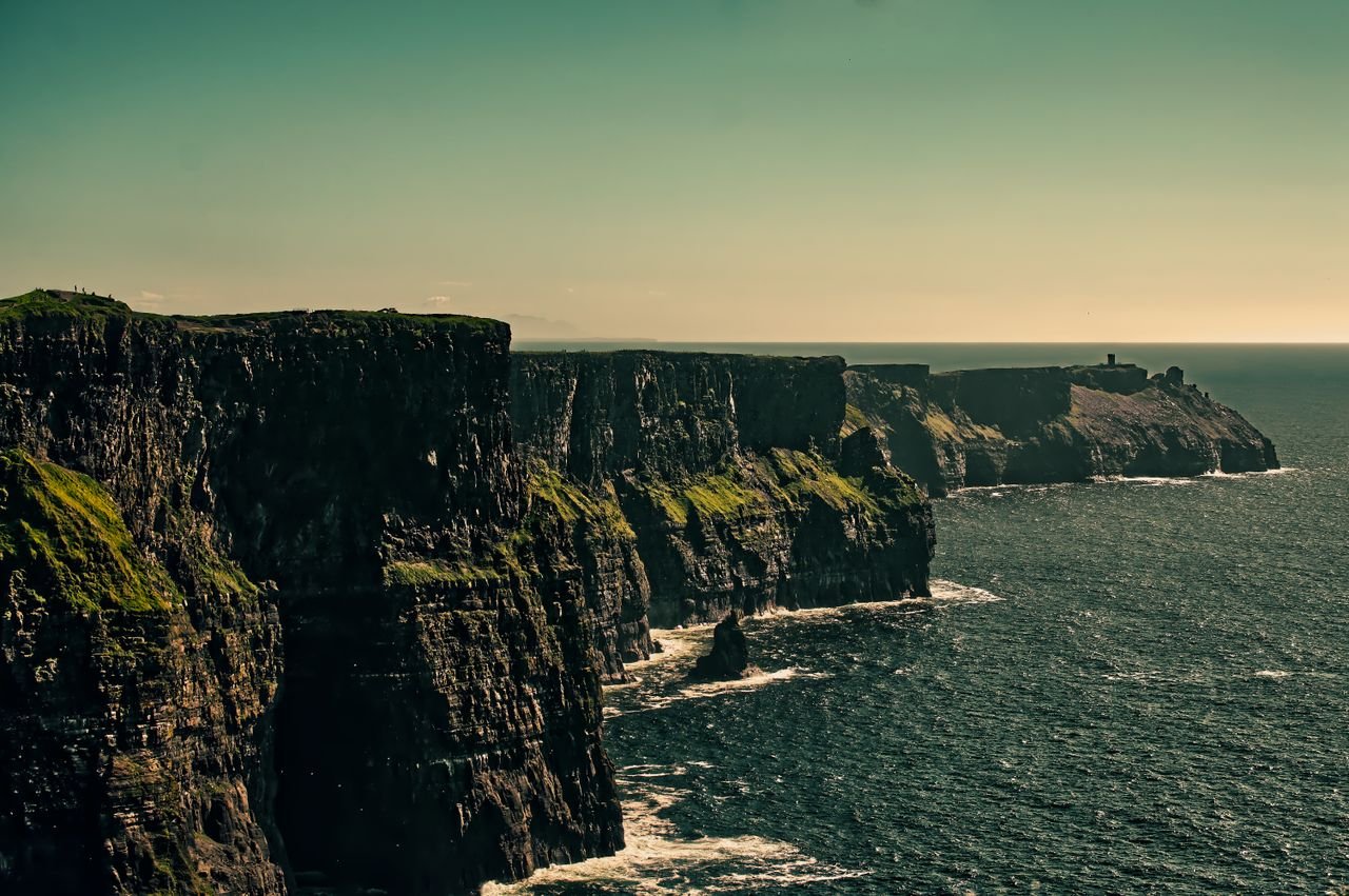 Breathtaking view of Ireland's Cliffs of Moher under a bright sky.